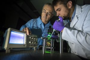 Associate professor of mechanical engineering George Lykotrafitis, left, and Ph.D. student Kostyantyn Partola demonstrate their whole blood rheometer technology. (Sean Flynn/UConn Photo)