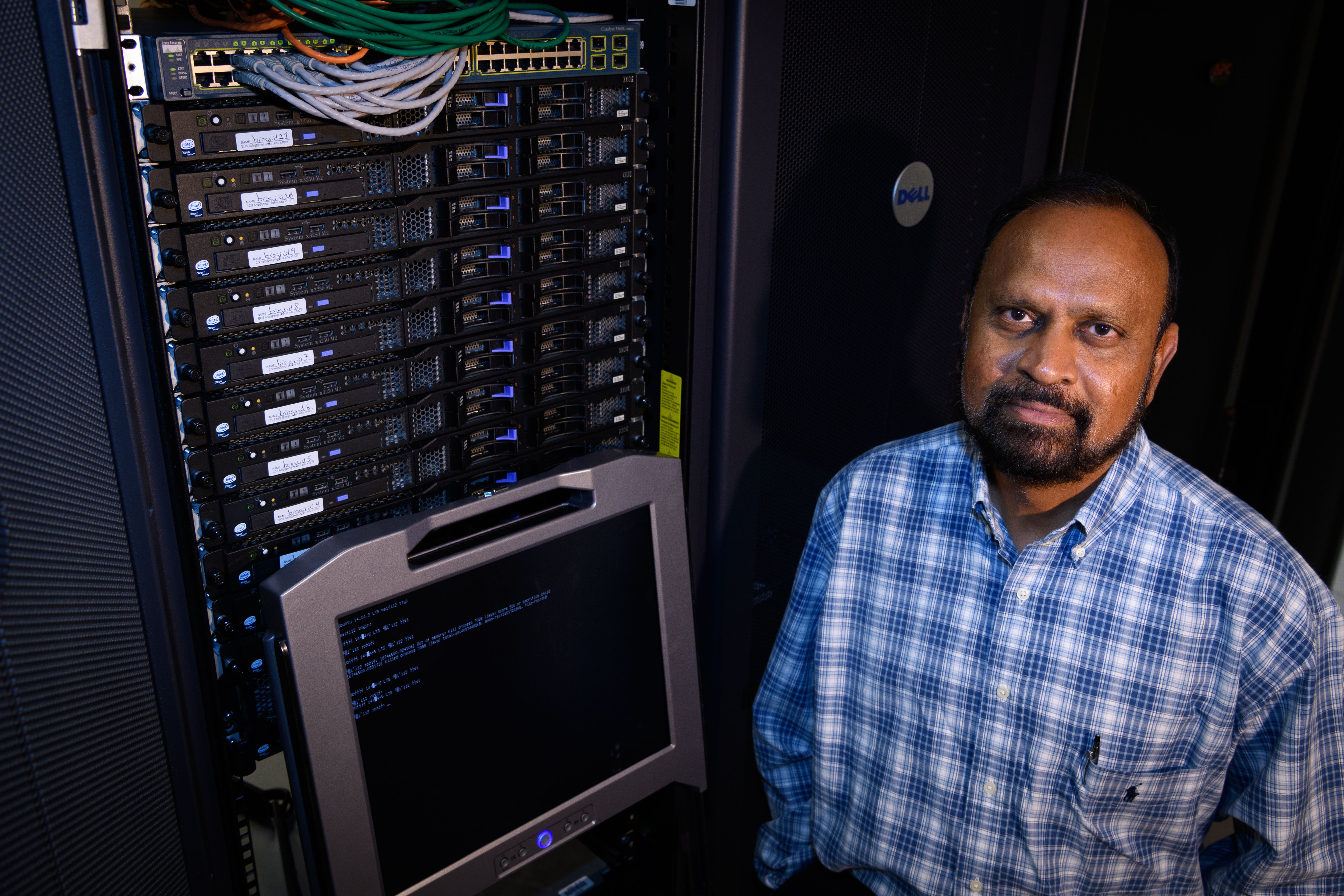 Board of Trustees Distinguished Professor of Computer Science & Engineering Sanguthevar Rajasekaran stands in front of a rack of computer servers at the Booth Engineering Center for Advanced Technology on Aug. 21, 2017. (Peter Morenus/UConn Photo)