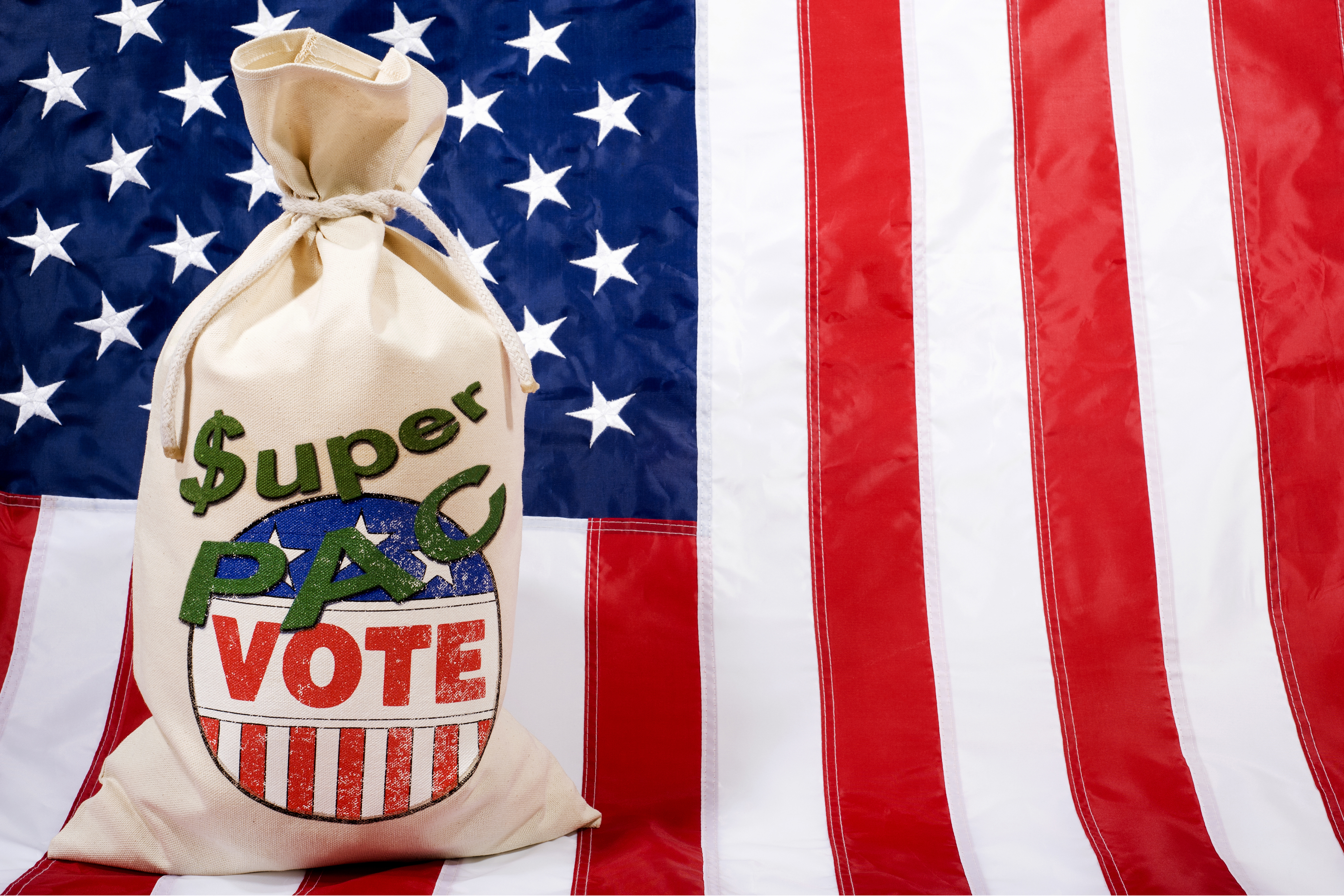 Money bag against a U.S. flag as background. Concept of the Super PACs' influence on the Presidential elections in the United States. (Getty Images)