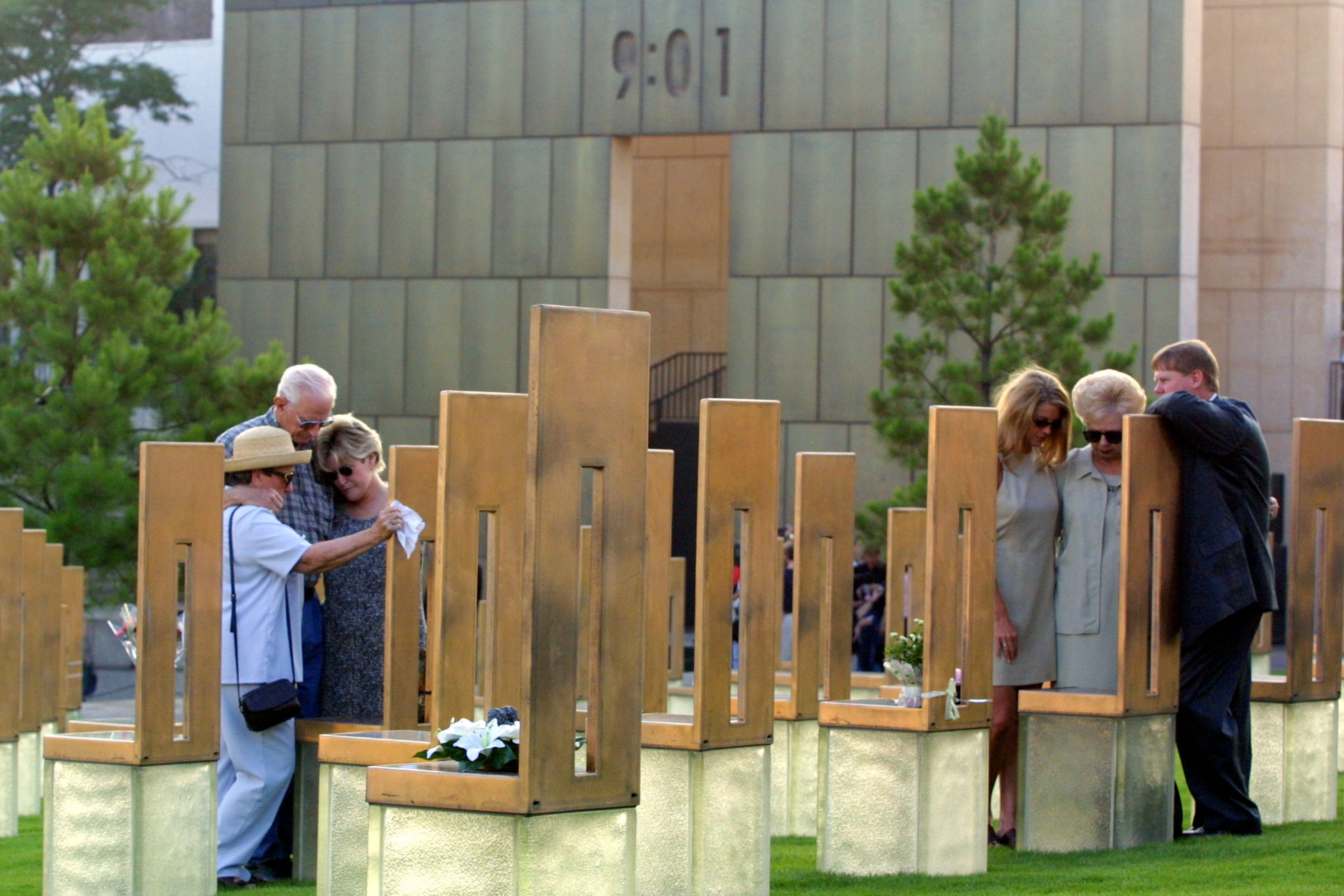 Mourners gather at the Oklahoma City National Memorial around chairs representing relatives killed during the 1995 bombing, on the day perpetrator Timothy McVeigh was executed, June 11, 2001. On the wall behind them, the time when the bomb was detonated is recorded at 9:01. (Joe Raedle/Getty Images)