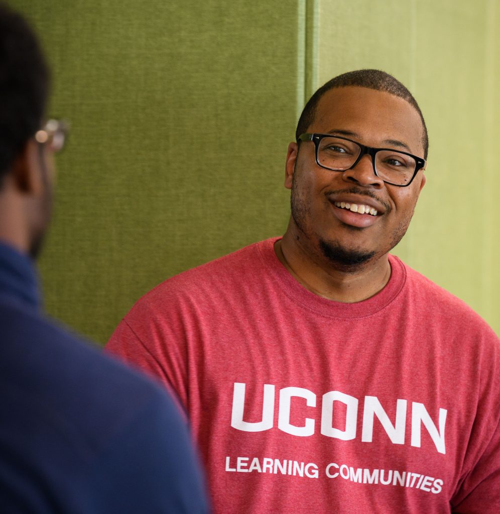 Erik Hines, assistant professor of educational psychology and director of ScHOLA²RS House, speaks with a student. (Peter Morenus/UConn Photo)
