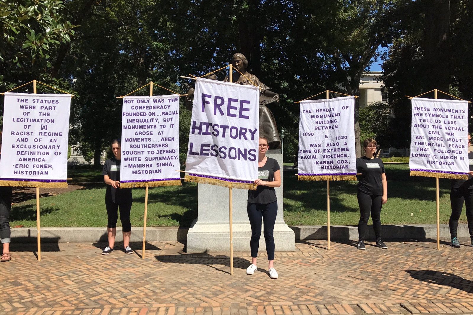 Students from North Carolina State’s Public History program protest Confederate statues, quoting Sinha’s New York Daily News opinion piece.