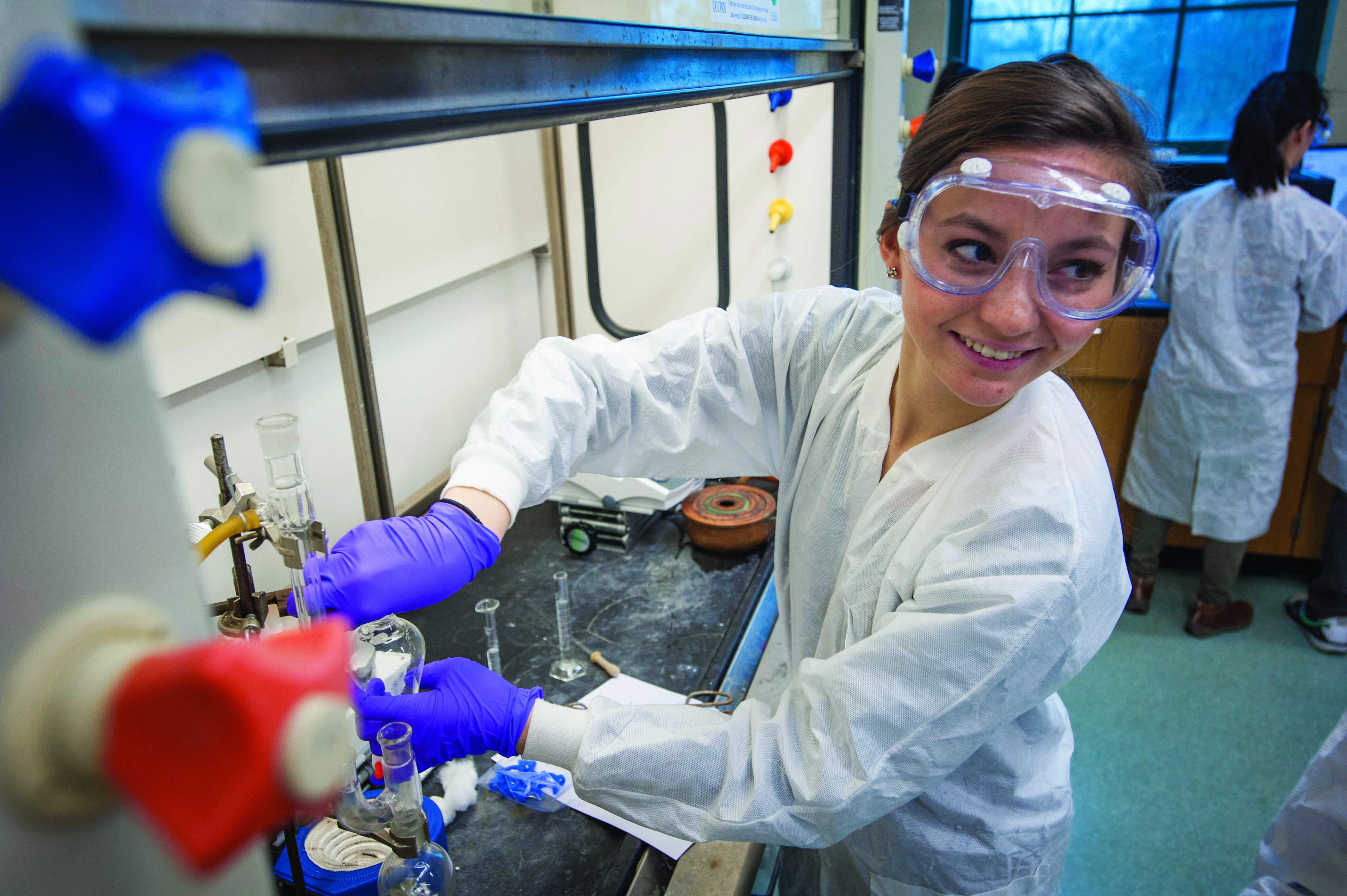 Bridget Oei performs an experiment with classmates in a chemistry lab. (Sean Flynn/UConn Photo)