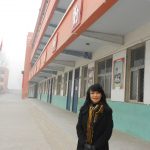 Cindy Tian, UConn professor of animal science in the College of Agriculture, Health, and Natural Resources, stands outside the 'Hall of Fame' at the Central Elementary School of Wei County, Hebei Province, in China. The entire hall is decorated with photos and descriptions of Yang's accomplishments. (Photo courtesy of Cindy Tian)