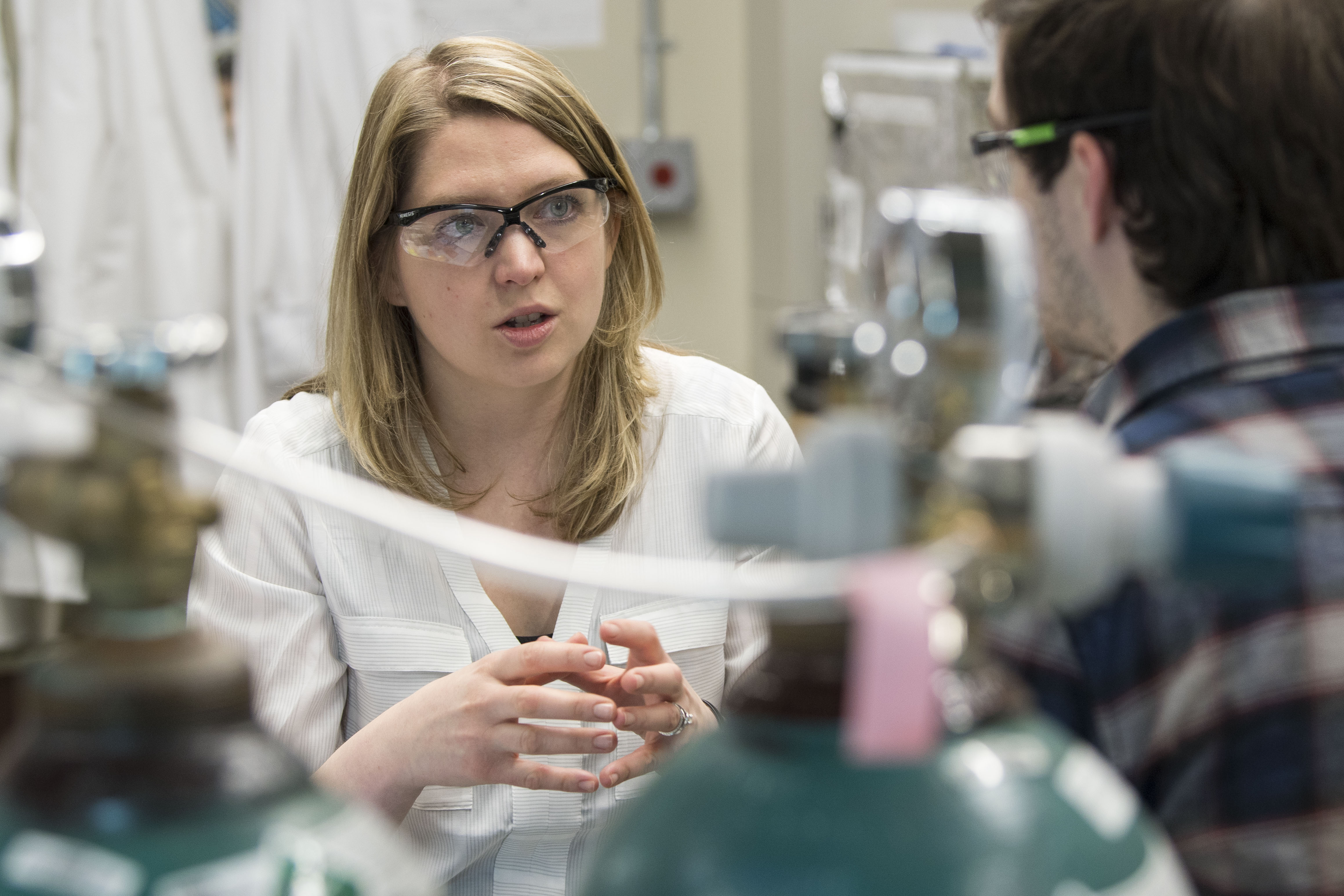 Jessica Rouge, assistant professor of chemistry, talking with graduate student Josh Santiana in her research lab in the Chemistry Building. (Sean Flynn/UConn Photo)