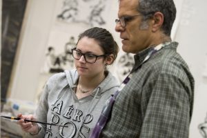 Rachel Manus, a sophomore majoring in fine arts, discusses her painting with Professor Guarino. (Garrett Spahn/UConn Photo)