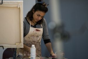 Marissa Aldieri '18, an individualized major, works on her painting in Professor Guarino's Basic Painting class. (Garrett Spahn/UConn Photo)