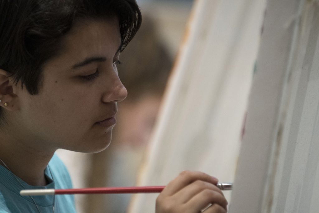 Jessica Ortegon, a senior majoring in fine arts, focuses on her work in Professor Brad Guarino's Basic Painting class. (Garrett Spahn/UConn Photo)