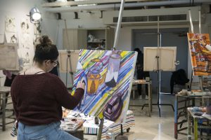 Katie Ouimette, a junior majoring in fine arts, works on her painting in Professor Guarino's class. (Garrett Spahn/UConn Photo)