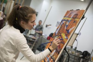 Sally Kirdziel, a senior majoring in fine arts, works on her painting in Professor Guarino's class. (Garrett Spahn/UConn Photo)