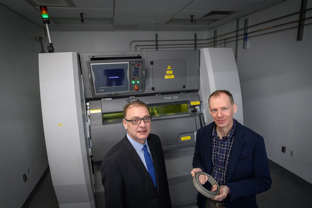 Researchers Pamir Alpay, left, and Rainer Hebert, hold a sample of 3-D metal printing at UConn's Innovation Partnership Building. (Peter Morenus/UConn Photo)