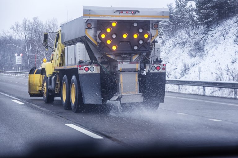 A truck spreads grit and salt on the highway. (Getty Images)