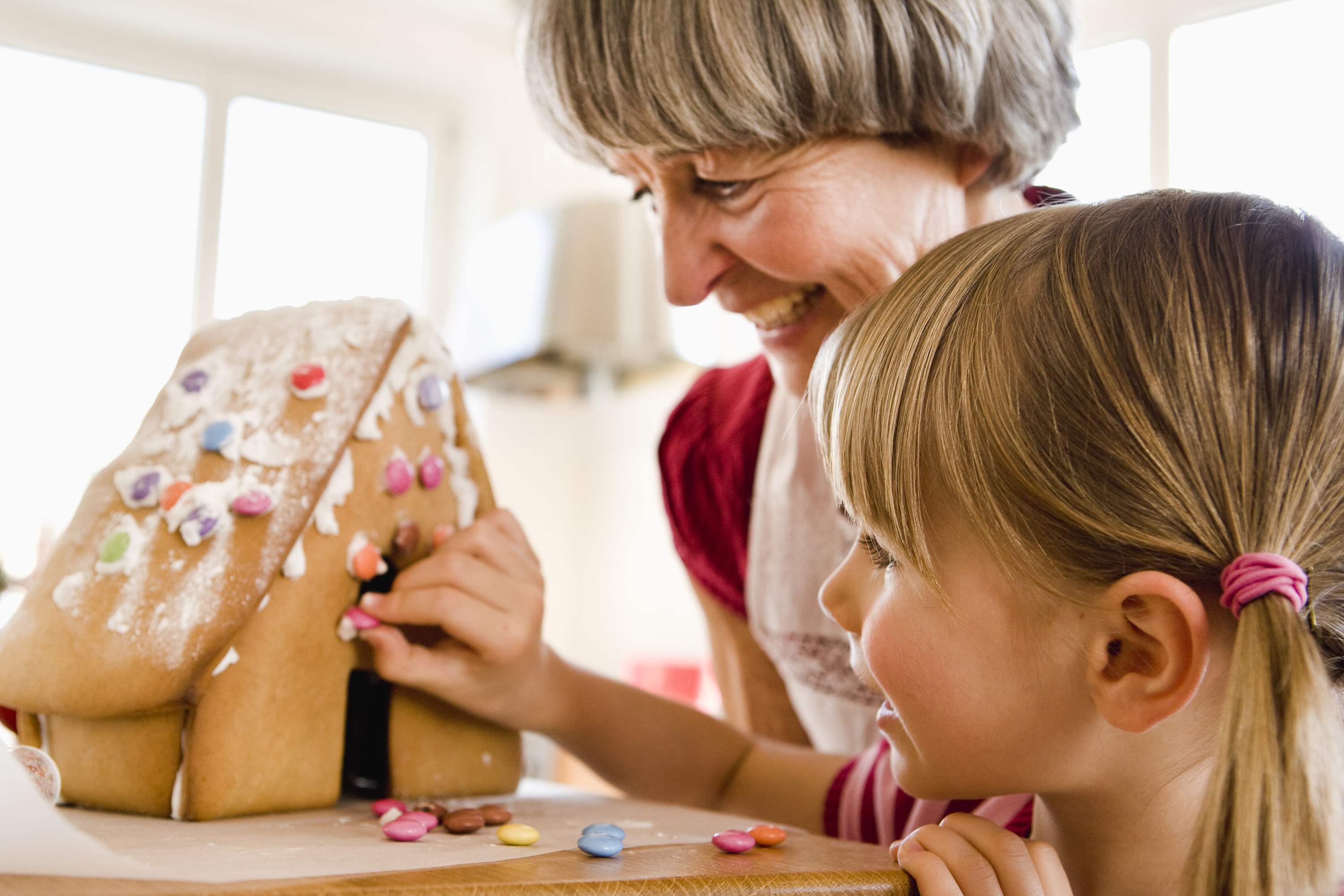 Grandma and granddaughter making a gingerbread house. (Getty Images)