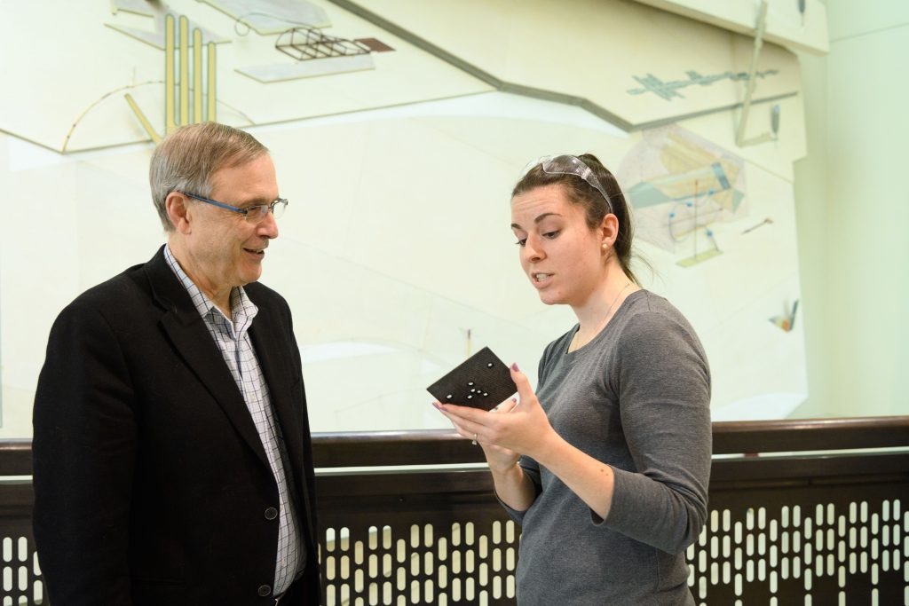 Newly named NAI Fellow Steven Suib, left, with Shannon Poges '17 Ph.D. at the Chemistry Building. Poges is holding a sample of a composite material produced in their lab. (Peter Morenus/UConn Photo)