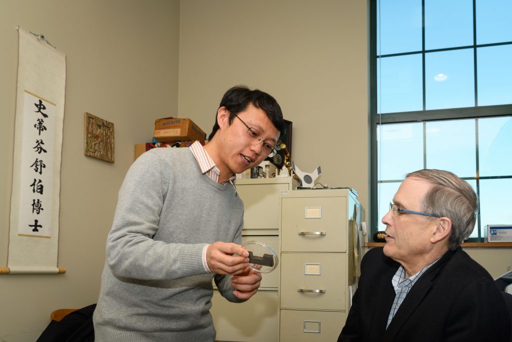 Steven Suib, Board of Trustees Distinguished Professor of Chemistry, right, with Junkai He, a Ph.D. candidate, at his office in the Chemistry Building. (Peter Morenus/UConn Photo)