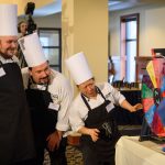 Gary Ellis, left, Scott Chapman, and Susan Chang, all of McMahon dining, watch as they spin a wheel to select an additional ingredient for their entry during the Boiling Point competition. (Peter Morenus/UConn Photo)