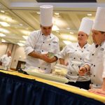 Mathew Nichols, left, Hannah Lee, and Bill McKay look over their ingredients at the start of the Boiling Point competition. (Peter Morenus/UConn Photo)