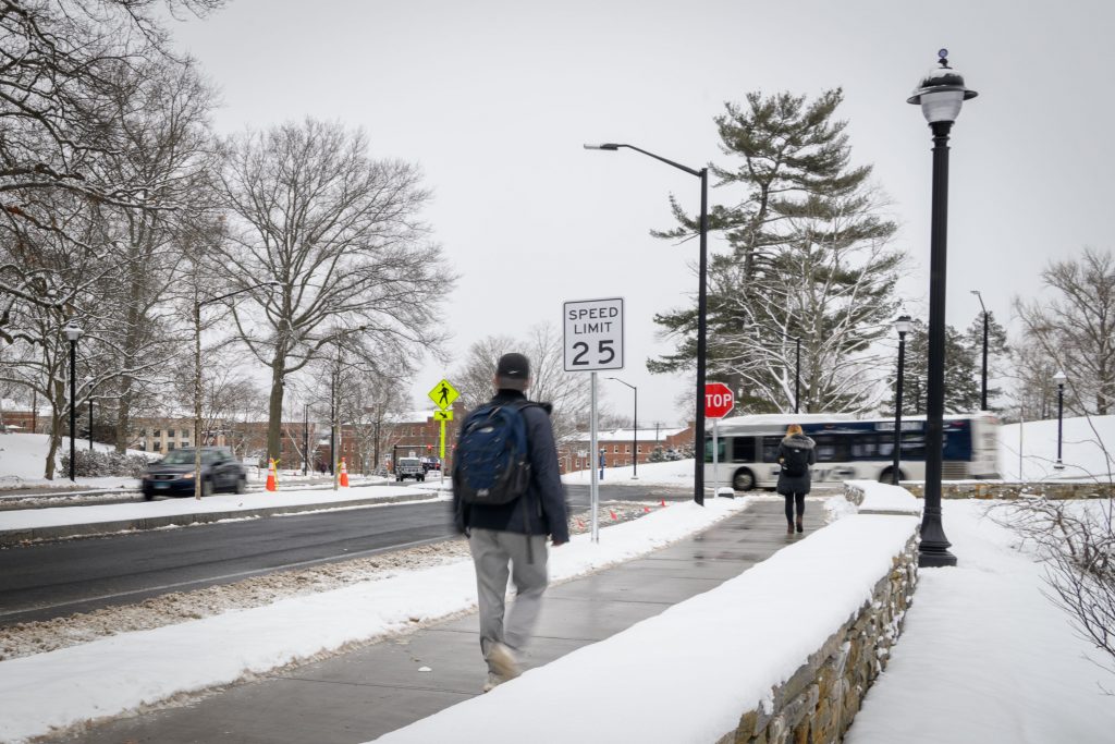 A snowy view of North Eagleville Road on Jan. 30, 2018, showing renovations including a new median, expanded sidewalk, and stone wall. (Peter Morenus/UConn Photo)