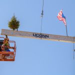 Construction workers set the signed beam in place atop the new Student Recreation Center. (Peter Morenus/UConn Photo)