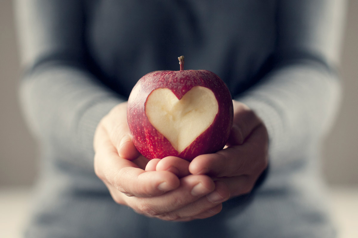 An apple with a heart-shape carved out of it. (Getty Images)