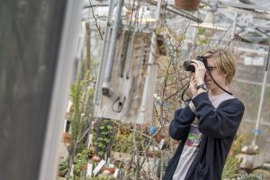 Mitch Britton '19 (SFA) takes photos at the UConn Biodiversity Education and Research Greenhouses.