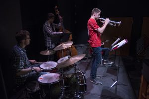 From left, Steven McArdle on drums, Nathan Giordano on bass, and Grant Eagleson on trumpet, all senior music majors, play at “Jazz Night at the Ballard.” (Garrett Spahn ’18 (CLAS)/UConn Photo)