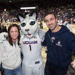 Ryan and Laura Marcoux pose for a picture with the Husky mascot while attending a women's basketball game in Gampel Pavilion during their recent visit to Storrs. (Stephen Slade '89 (SFA) for UConn)