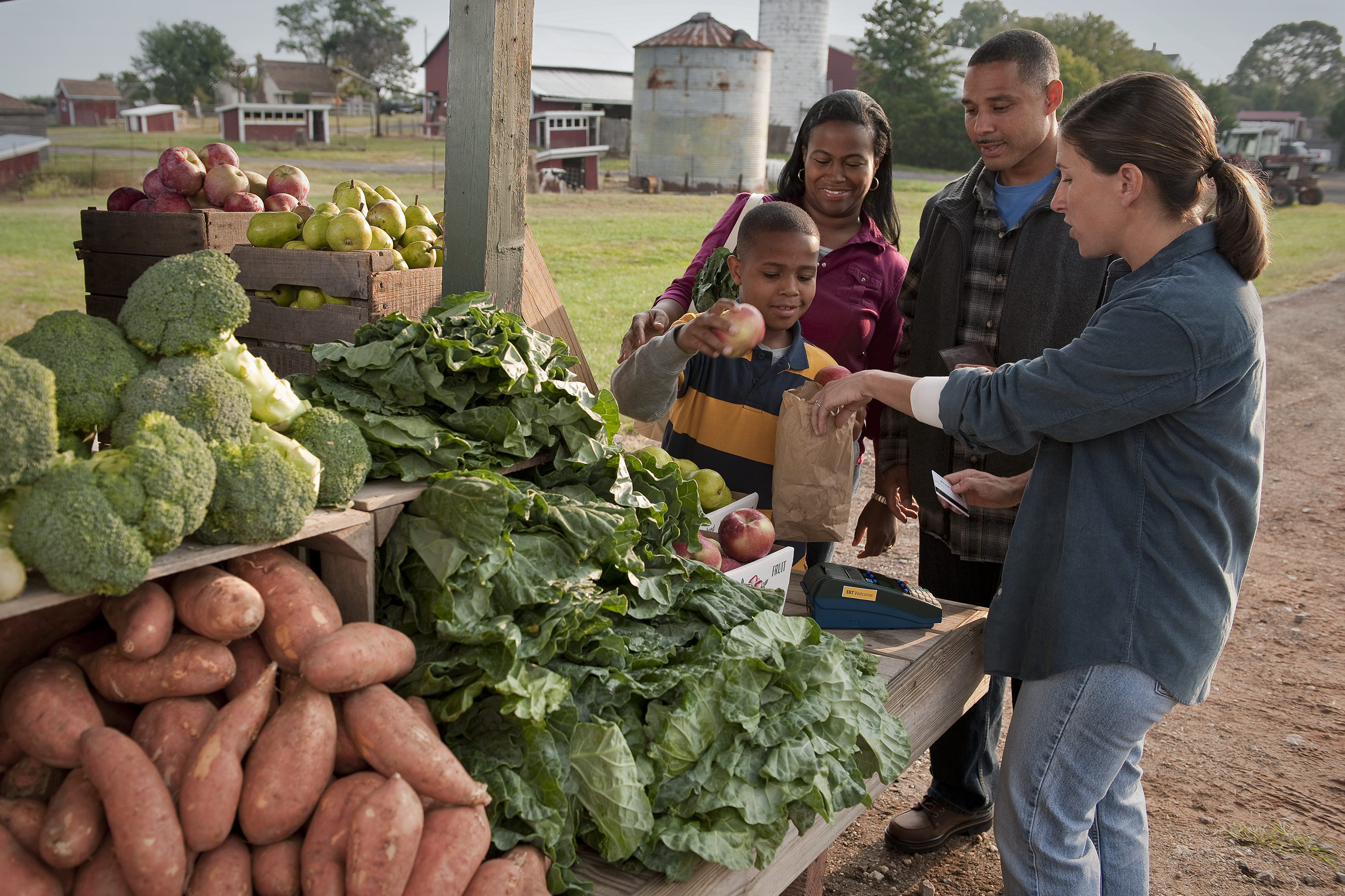 A family purchases produce from a farmers market vendor. (SNAP-Ed Photo Gallery, USDA)