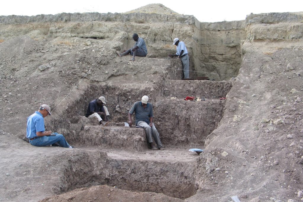 In this Olorgesailie Basin excavation site, red ocher pigments were found with Middle Stone Age artifacts. The light brown and gray layers provide evidence of ancient soils and of landscapes affected by earthquakes and other seismic activity, factors that rapidly altered the environment and resources on which human ancestors depended for survival. (Human Origins Program, Smithsonian)