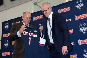 Athletic director David Benedict, left, gives Dan Hurley a UConn 1 shirt during a welcome event at the Werth Family Basketball Champions Center.