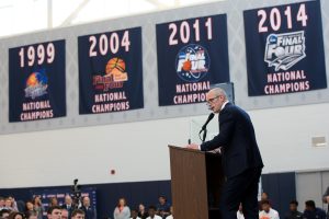 Dan Hurley addresses the crowd, against a backdrop of four UConn Huskies National Championship banners.