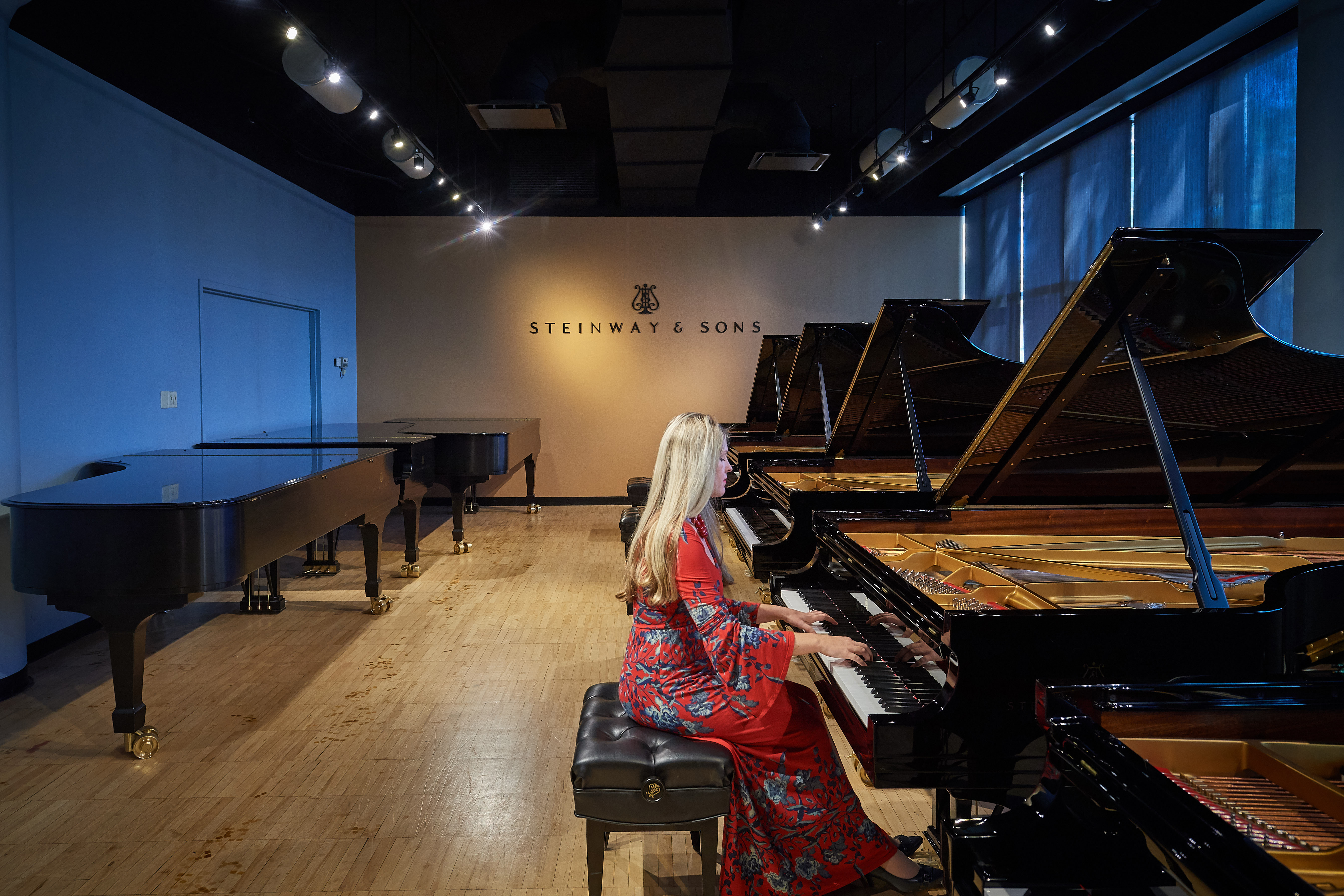 Angelina Gadeliya, assistant professor-in-residence and director of keyboard studies, tests grand pianos at the Steinway & Sons factory in Queens, New York, last October. (Peter Morenus/UConn Photo)