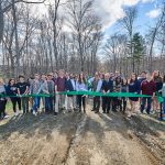Richard Miller, director of the Office of Environmental Policy, prepares to cut the ribbon at the dedication of the new trailhead to the Hillside Environmental Education Park on April 26, 2018. (Peter Morenus/UConn Photo)