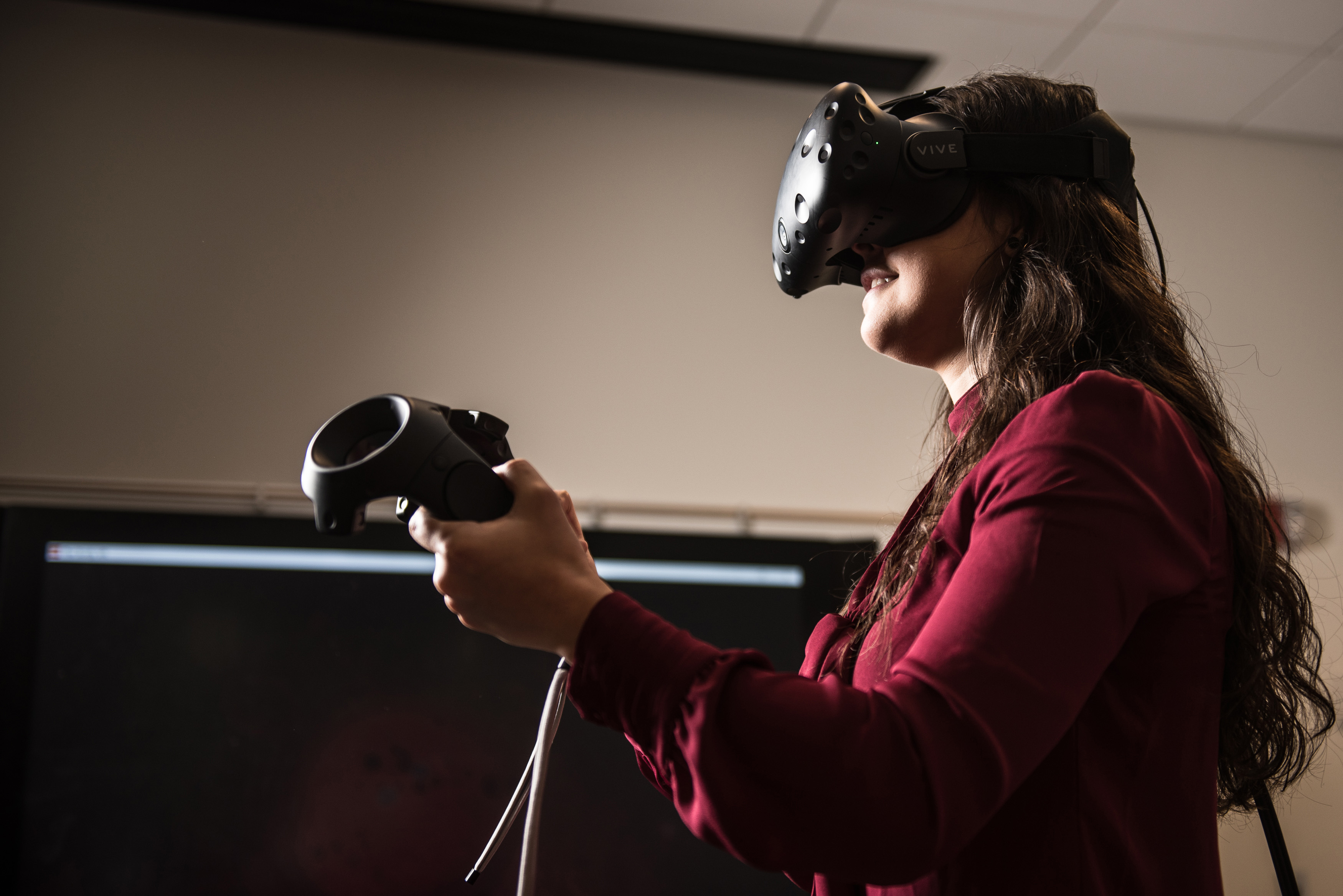 With a virtual reality headset on, junior Carina Zamudio ’19 (CLAS) spent part of a Friday afternoon trying to slay villains who were intent on breaching the security around a virtual castle. (Nathan Oldham/UConn School of Business Photo)