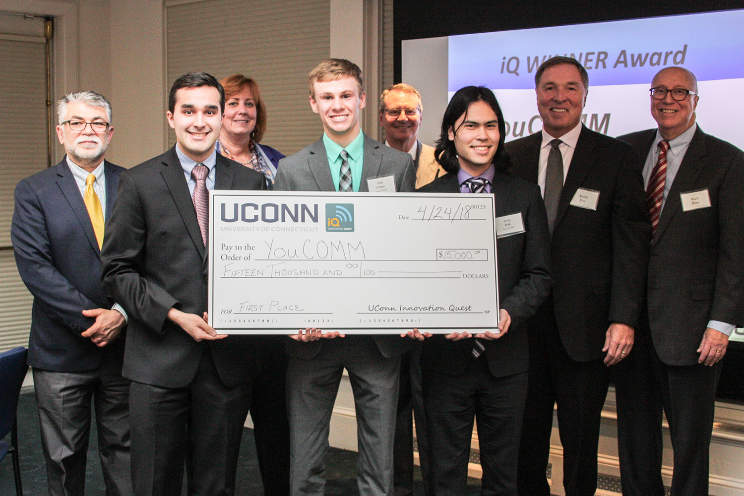 From left, Kazem Kazerounian, dean of the School of Engineering; YouCOMM co-founder Daniel Yasoshima; Lucy Gilson, head of the Management Department; YouCOMM co-founder Tom Cotton; Provost Craig Kennedy; student Jeren Koh; UConn iQ founder Keith Fox '80 and iQ Director Professor Rich Dino pose for a photo after the announcement that YouCOMM won the grand prize. (Nicolle Anderson/UConn School of Business)