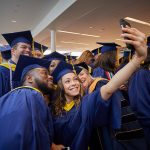 Bliss Dasilva '10 (CAHNR), '18 (NUR) takes a selfie with classmates at the Carolyn Ladd Widmer Wing of Storrs Hall before the start of the School of Nursing Commencement procession on May 5. (Peter Morenus/UConn Photo)