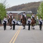 The UConn Morgan Drill Team leads the the College of Agriculture, Health, and Natural Resources Commencement procession along Hillside Road. (Peter Morenus/UConn Photo)