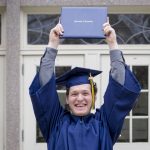 Kevin Sarra ‘18 (CLAS) holds up his diploma after the College of Liberal Arts and Sciences Commencement ceremony. (Sean Flynn/UConn Photo)