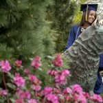 Amanda Shrouder ‘18 (CLAS) poses with the Husky statue after the College of Liberal Arts and Sciences Commencement ceremony. (Sean Flynn/UConn Photo)