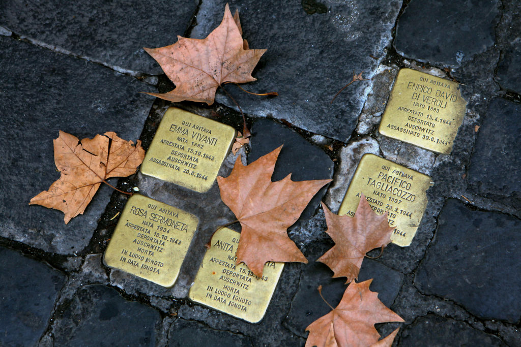 Small bronze plaques in memory of victims of the Holocaust are seen between the paving stones of the Jewish Ghetto in Rome, Italy. The Roman Jewish Ghetto was originally established by Pope Paul IV in July 1555 as a walled quarter with its gates locked at night and survived until the walls were torn down in September 1870 when it the neighborhood remained the heart of the city's Jewish community. In October 1943 the Holocaust reached Rome when German Nazi troops entered the area and deported over 2,000 Jews, of which only about 100 survived the war. The quarter today is a bustling neighborhood famous for its ethnic Jewish food and restaurants. (Photo by David Silverman/Getty Images)