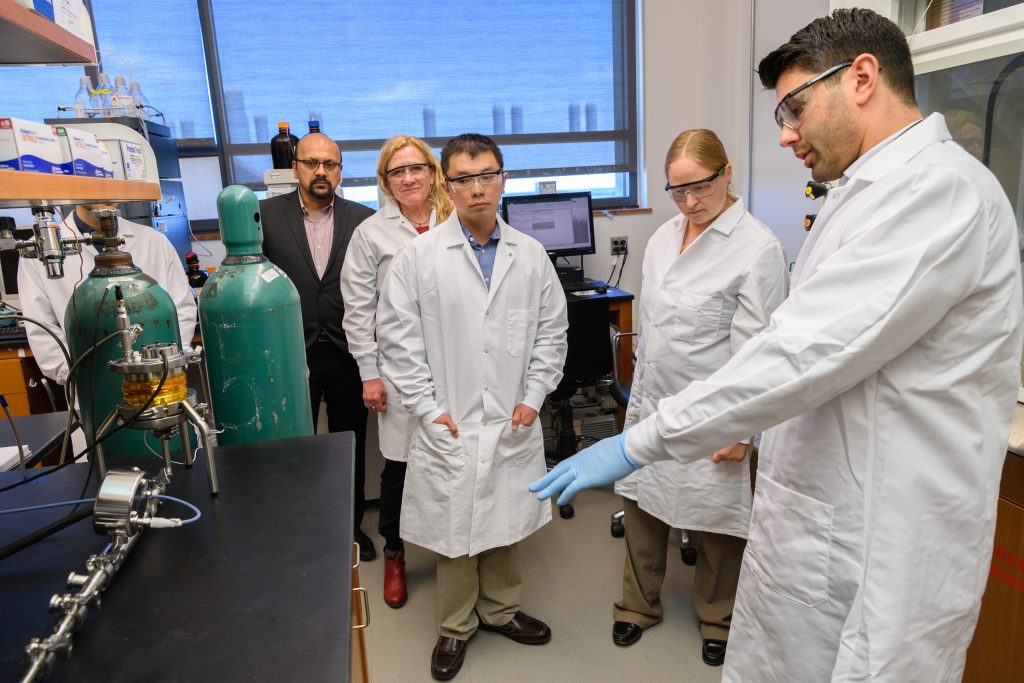 Antonio Costa, assistant research professor of pharmaceutical science, right, explains the apparatus for continuous processing of liposome drug products at the Pharmacy/Biology Building. From left are Bodhi Chaudhuri, associate professor of pharmacy, Diane Burgess, Board of Trustees Distinguished Professor of Pharmaceutics, and Katherine Tyner and Su-Lin Lee, both of the FDA’s Office of Pharmaceutical Quality. (Peter Morenus/UConn Photo)