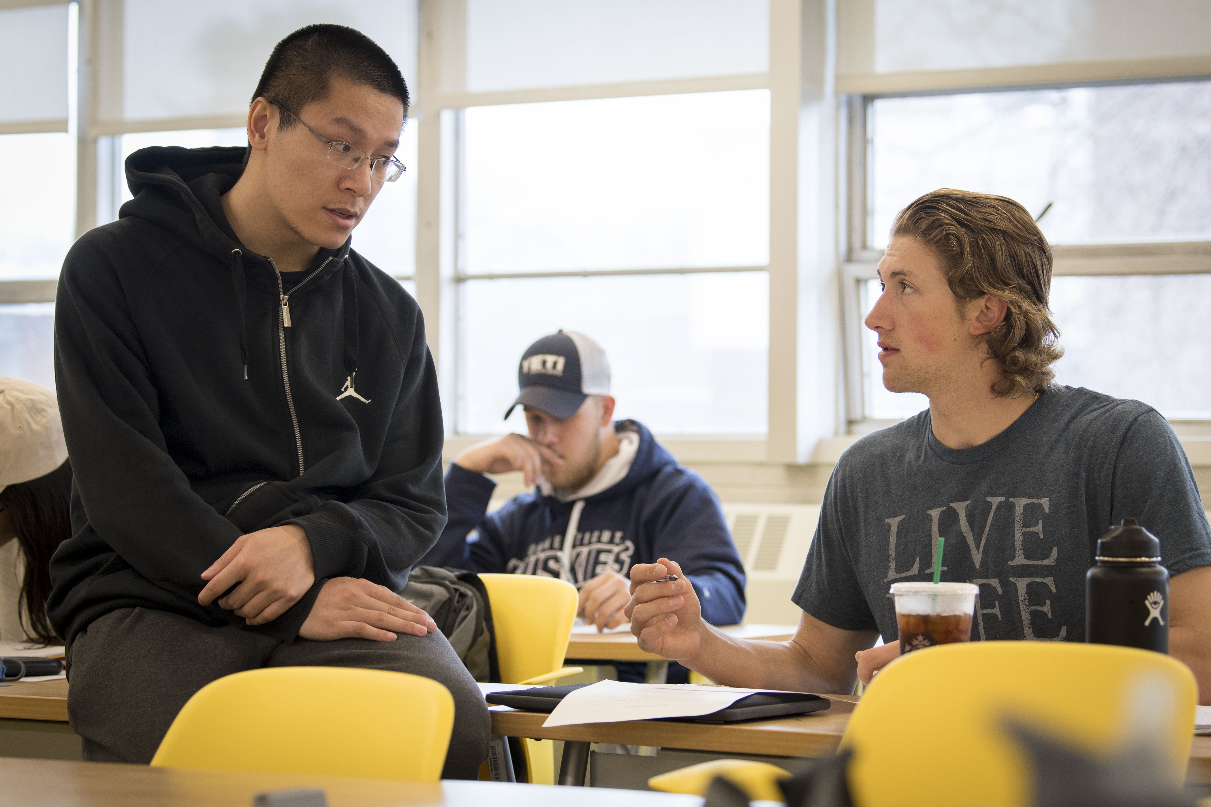 Baseball player Chris Winkel ‘20 (BUS), right, talks with teaching assistant Jungang Li during a Calculus for Business and Economics class in Monteith. To Winkel, being a Husky is having 'a mindset to embrace every obstacle ahead ... and overcome it.' (Sean Flynn/UConn Photo)