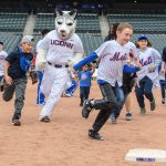 Jonathan the Husky runs with children during the Mr. Met Dash following a New York Mets baseball game at Citi Field in Queens New York on June 3, 2018. (Peter Morenus/UConn Photo)