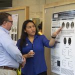 Sthefany Calle, a molecular and cell biology major in the College of Liberal Arts and Sciences, speaks about her research at the McNair Scholars Poster Session on July 25, 2018. (Christine Buckley/UConn Photo)