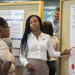 Kerryann Ashley, a molecular and cell biology major in the College of Liberal Arts and Sciences, speaks about her research at the McNair Scholars Poster Session on July 25, 2018. (Christine Buckley/UConn Photo)