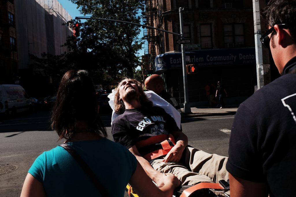 A man is consoled as paramedics take him to the hospital for what is thought to be an overdose of K2 or 'Spice,' a synthetic marijuana drug (Photo by Spencer Platt/Getty Images)