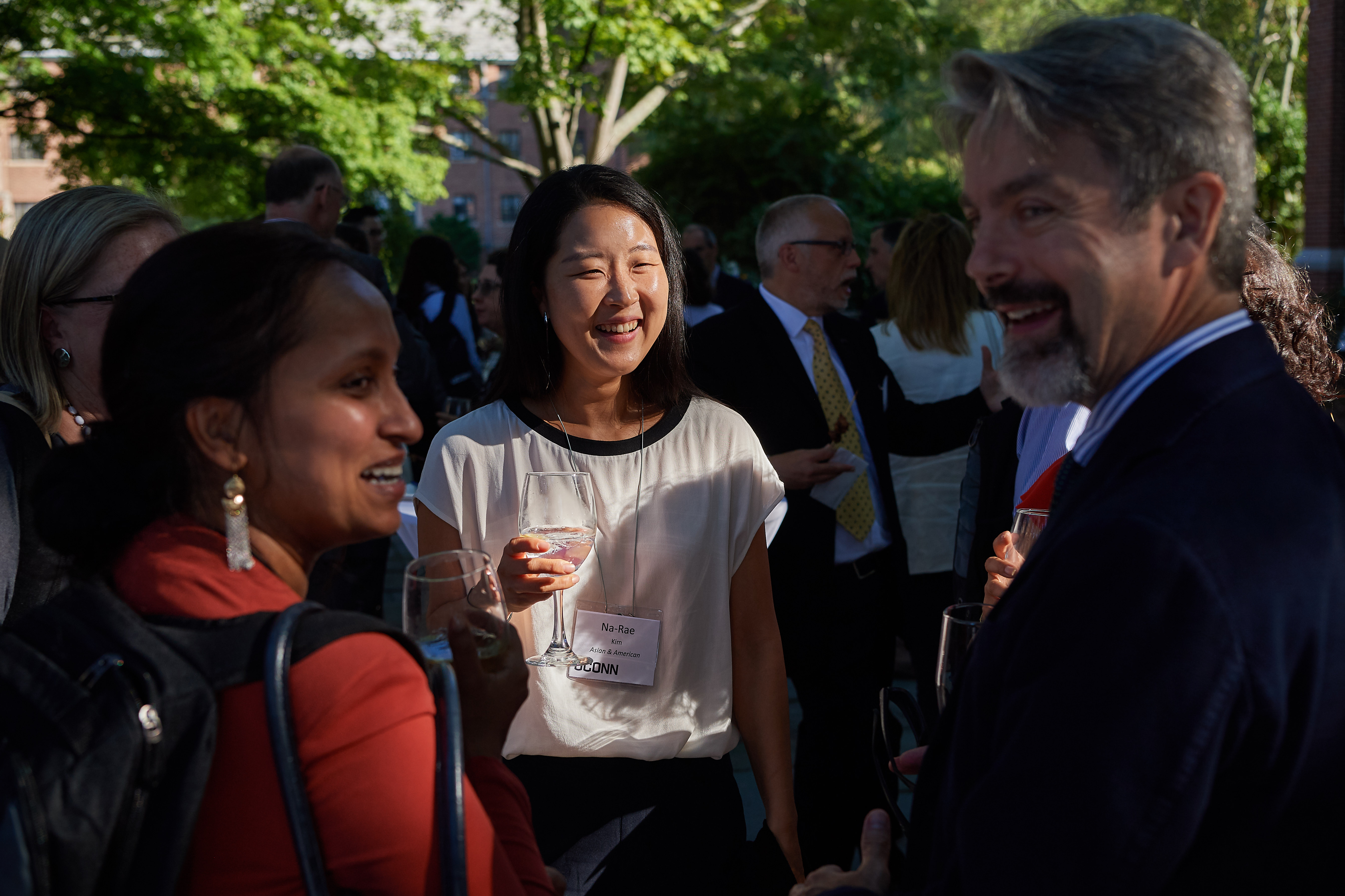 Na-Ree Kim, center, assistant professor in residence of Asian and Asian-American studies, Rupal Parekh, left, assistant professor of social work,and John Volin, vice provost for academic affairs speak at a reception following new faculty orientation on the patio of the William Benton Museum of Art. (Peter Morenus/UConn Photo)
