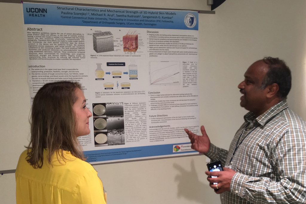 PIE Fellow Paulina Szarejko of Central Connecticut State University discusses her summer research project poster with her UConn Health mentor Dr. Sangamesh Kumbar, associate professor of orthopedic surgery and biomedical engineering at UConn Health. (Lauren Woods/UConn Health Photo)