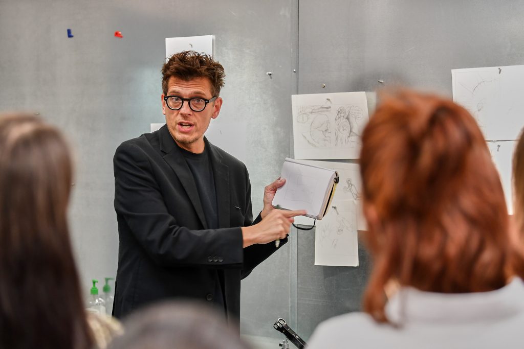 Illustrator Dwayne Booth, aka Mr. Fish, participates in a group critique of students' draft illustrations during a class at the Bishop Center. (Peter Morenus/UConn Photo)