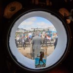 The University held a recommissioning ceremony on Sept. 13 for the school’s marine research vessel, the RV Connecticut, at the Avery Point Campus, after it underwent a complete makeover. Here, the ceremony is seen though a porthole of the ship. (Peter Morenus/UConn Photo)